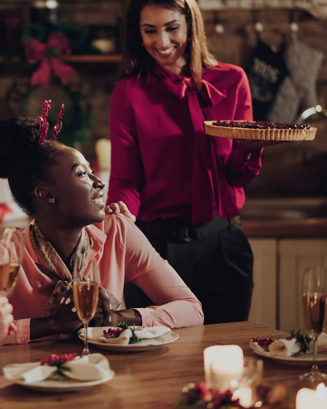 A lady seated at a festive dinner is presented with a large dessert