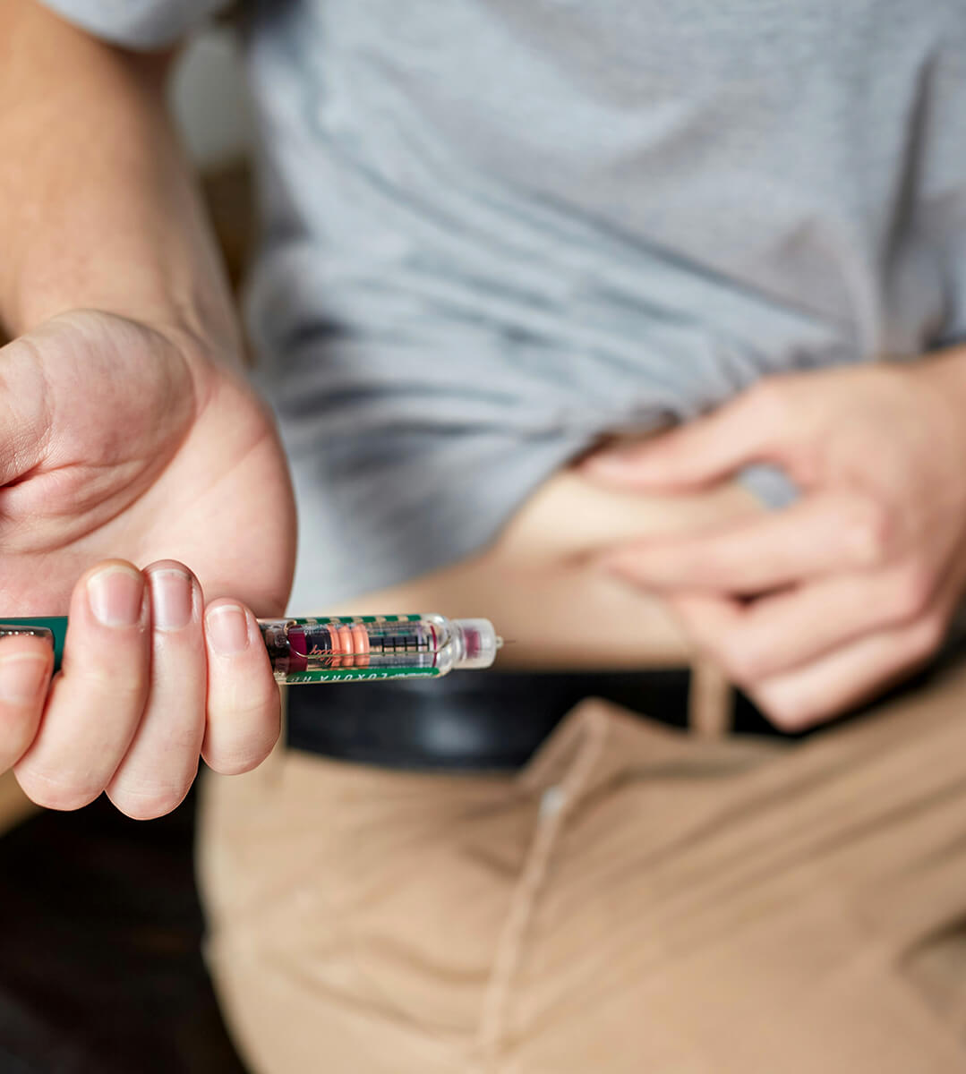 A middle-aged man is injecting himself with GLP-1 medication in his belly fat